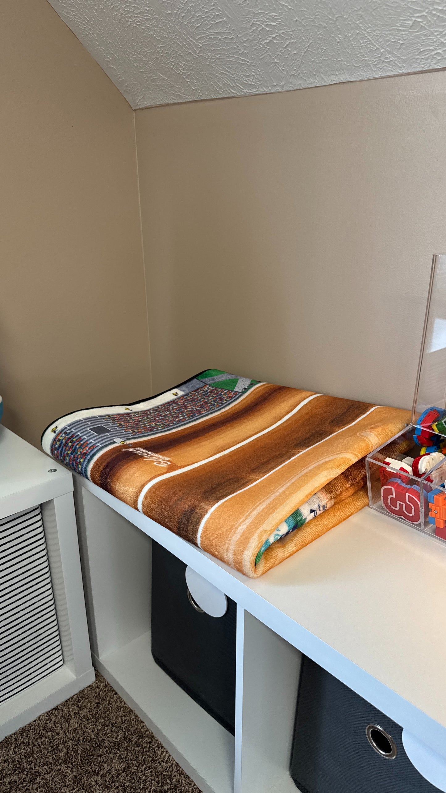 Dirt Track rug folded on shelf